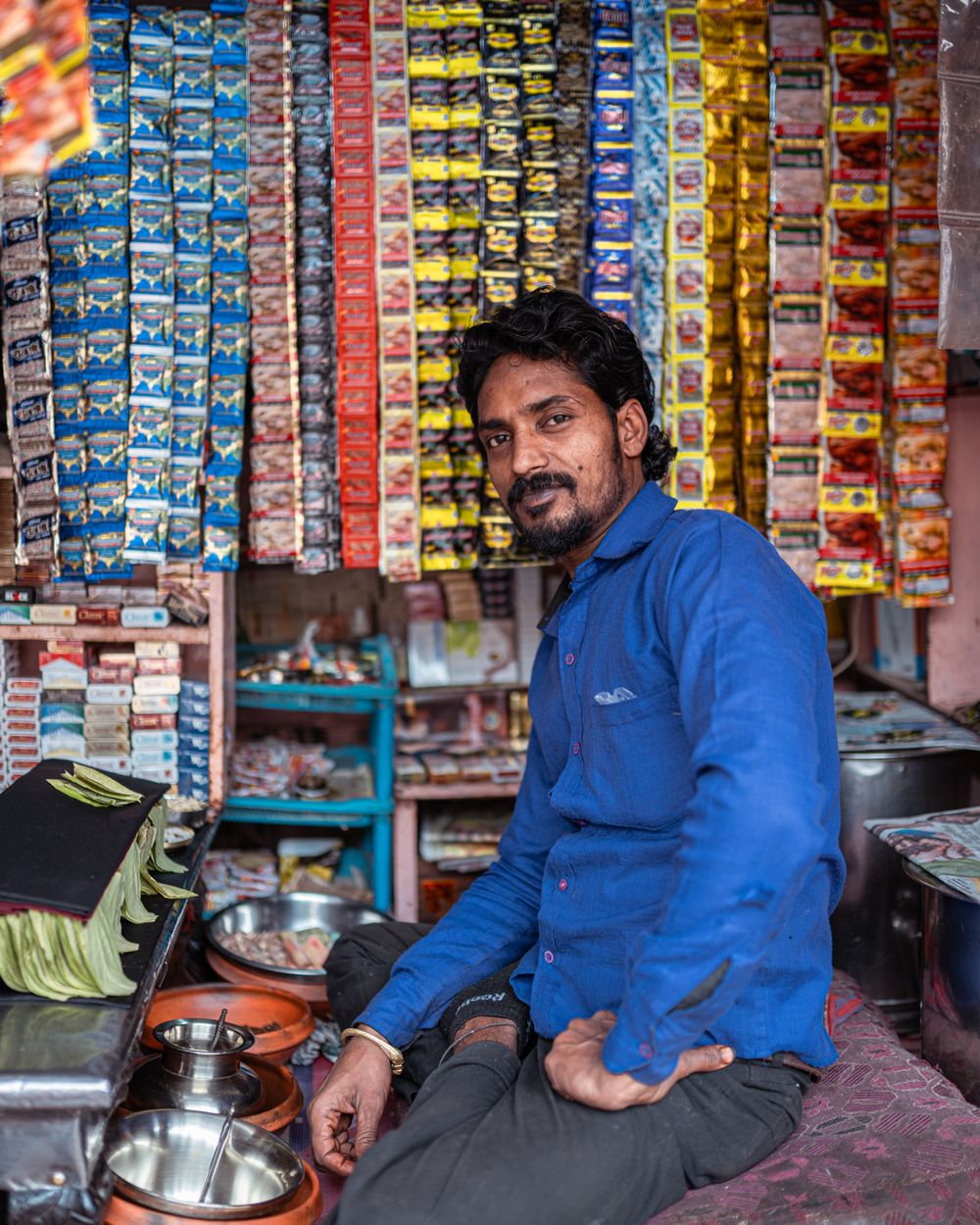 Local shop owner standing proudly at his shop counter in India